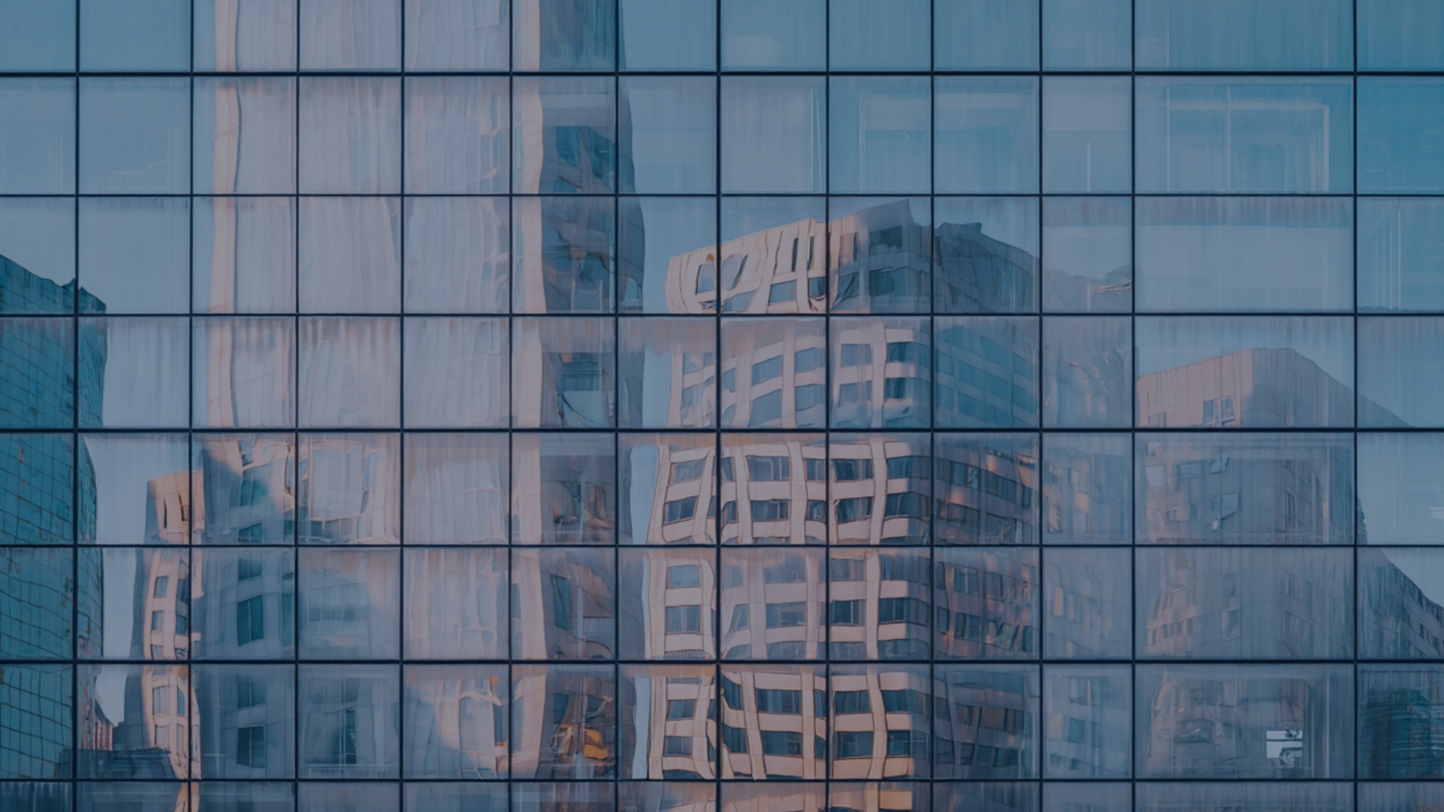Glass towers reflecting the surrounding cityscape